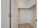 A simple, walk-in closet with a wooden hanging bar and tile floors at 6221 S 45Th Gln, Laveen, AZ 85339