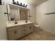 Bathroom featuring a double sink vanity with granite countertops, modern lighting, and a tiled shower at 6837 E Osborn Rd # F, Scottsdale, AZ 85251