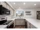 Bright updated kitchen with stainless steel appliances, a window overlooking the exterior, and floating shelves at 6837 E Osborn Rd # F, Scottsdale, AZ 85251