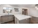 Bright kitchen featuring light gray cabinets, quartz countertops, floating shelves and a view to the backyard through the window at 6837 E Osborn Rd # F, Scottsdale, AZ 85251