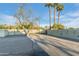 Spacious backyard with a block fence, gate, and mature palm trees in the background at 7125 N 2Nd Pl, Phoenix, AZ 85020