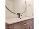 Modern bathroom vanity with a round mirror and bronze fixtures at 8130 N 32Nd Dr, Phoenix, AZ 85051