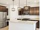 Modern kitchen featuring dark wood cabinets, stainless steel appliances, and a large island with pendant lighting at 8613 W Warner St, Tolleson, AZ 85353