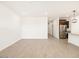 Spacious living room with light wood flooring leading to the kitchen with stainless appliances and granite countertops at 8613 W Warner St, Tolleson, AZ 85353