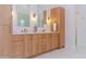 Double vanity bathroom featuring wood cabinetry, contemporary lighting, and elegant fixtures, perfect for a spa-like retreat at 9393 E Hunter Ct, Scottsdale, AZ 85262