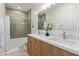 Bathroom featuring dual sinks with light wood cabinetry and tub with tiled shower at 9393 E Hunter Ct, Scottsdale, AZ 85262