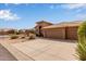 Lovely home featuring a tile roof, desert landscaping, and an extended driveway with a three-car garage at 9393 E Hunter Ct, Scottsdale, AZ 85262