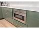 Green kitchen cabinets with built-in microwave and marble countertop at 9393 E Hunter Ct, Scottsdale, AZ 85262