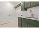 Bright laundry room features modern green cabinets, white walls and a convenient sink at 9393 E Hunter Ct, Scottsdale, AZ 85262