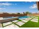 Backyard pool and spa with artificial turf and stone pavers at 9393 E Hunter Ct, Scottsdale, AZ 85262