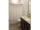 This is a bathroom featuring a vanity with dark cabinets and a shower with a white decorative curtain at 9804 E Red Giant Dr, Mesa, AZ 85212