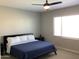 Neutral bedroom features a ceiling fan, a window and a navy blue comforter at 9804 E Red Giant Dr, Mesa, AZ 85212