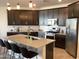 Well-lit kitchen featuring stainless steel appliances, a large island, and dark wood cabinetry at 9804 E Red Giant Dr, Mesa, AZ 85212