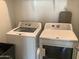 The laundry room features a white washer and dryer with utility shelving above at 9804 E Red Giant Dr, Mesa, AZ 85212