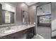 Ensuite bathroom features double sinks, granite countertop, and dark cabinets, with bedroom view at 9932 E Tumbleweed Ave, Mesa, AZ 85212