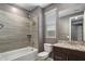 Bathroom featuring bathtub-shower, tile surround, decorative mirror, toilet, and granite countertop at 9932 E Tumbleweed Ave, Mesa, AZ 85212