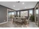 Bright dining room features a table set for six, large painting, sliding glass door to the exterior, and tile flooring at 9932 E Tumbleweed Ave, Mesa, AZ 85212