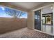 Covered patio with brick pavers leads to a brightly lit interior through a sliding glass door at 9932 E Tumbleweed Ave, Mesa, AZ 85212