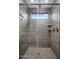 Contemporary bathroom shower with grey tiling, glass door, and overhead shower head at 9932 E Tumbleweed Ave, Mesa, AZ 85212