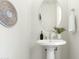 Modern powder room with pedestal sink, oval mirror, and stylish wall decorations at 1 Easy St # 11, Carefree, AZ 85377