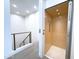 Hallway featuring an elevator with light wood interior and modern black metal cable railing overlooking the stairs at 1 Easy St # 3, Carefree, AZ 85377