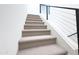 Close-up on carpeted stairs with a modern black metal and cable railing system on a clean, white wall at 1 Easy St # 3, Carefree, AZ 85377