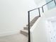 Carpeted staircase with modern black metal and cable railing against a clean white wall, providing a sleek design at 1 Easy St # 3, Carefree, AZ 85377