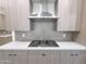 Close up on the gray cabinets, stainless steel range hood, gray tile backsplash, and gas cooktop at 1 Easy St # 6, Carefree, AZ 85377