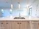 Close-up of the kitchen island with a dual basin sink, stainless steel dishwasher, pendant lights, and modern hardware at 1 Easy St # 6, Carefree, AZ 85377