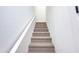 Carpeted staircase with white walls and a minimalist handrail leading to the upper level of the home at 1 Easy St # 7, Carefree, AZ 85377
