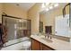 Bright bathroom featuring glass shower door, modern fixtures, and wood vanity at 12915 W Lone Tree Trl, Peoria, AZ 85383