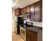 Traditional kitchen with stainless steel microwave, range, dark cabinets, and black countertops at 14145 N 92Nd St # 2004, Scottsdale, AZ 85260