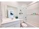 Bright bathroom showcasing a vanity, toilet, and tub with white tile surround, complemented by stylish decor and fixtures at 15033 W Hackamore Dr, Surprise, AZ 85387