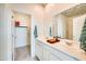 Elegant bathroom featuring double sinks, white cabinetry, and a well-lit mirror, with a walk-in closet nearby at 15033 W Hackamore Dr, Surprise, AZ 85387