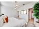 Bright bedroom featuring a minimalist design, a leafy green plant, and a view of the closet and ensuite bathroom at 15033 W Hackamore Dr, Surprise, AZ 85387