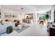 Bright and airy living room featuring tile flooring, a modern sofa, and seamless access to the kitchen and dining area at 15033 W Hackamore Dr, Surprise, AZ 85387