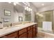 A well-lit bathroom features double sinks and a glass enclosed shower at 15696 W Roanoke Ave, Goodyear, AZ 85395