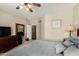 This bedroom features a ceiling fan, a dresser, and carpeted floors at 15696 W Roanoke Ave, Goodyear, AZ 85395