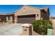 Two-car garage with desert landscaping, mailbox, and attached solar panels at 15696 W Roanoke Ave, Goodyear, AZ 85395