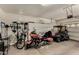 Spacious garage with a motorcycle, golf cart, overhead storage, and ample storage solutions at 15696 W Roanoke Ave, Goodyear, AZ 85395