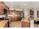 This kitchen features stainless steel appliances, granite countertops, and wood cabinets at 15696 W Roanoke Ave, Goodyear, AZ 85395