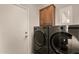 Modern laundry room featuring new LG washer and dryer units with wood storage cabinet at 15696 W Roanoke Ave, Goodyear, AZ 85395