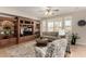 Living room featuring tile floors, built-in shelving, and lots of natural light at 15696 W Roanoke Ave, Goodyear, AZ 85395