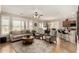 Open-concept living room with tile floors, large windows, and comfortable seating at 15696 W Roanoke Ave, Goodyear, AZ 85395