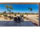 Outdoor dining area with seating for six, surrounded by desert landscaping and golf course view at 15696 W Roanoke Ave, Goodyear, AZ 85395