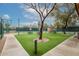 Outdoor community tennis court area with tables and chair sets and lush green grass at 15696 W Roanoke Ave, Goodyear, AZ 85395