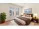 Bright bedroom featuring a modern bed, wood floors, white shutters, and a ceiling fan at 16100 W Galleria Ln, Surprise, AZ 85374