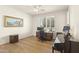 Bedroom with a desk and piano, featuring hardwood floors and a ceiling fan, providing a flexible and stylish space at 16100 W Galleria Ln, Surprise, AZ 85374