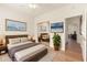 Bedroom featuring light wood floors, white walls, leafy plants and a view into an adjacent room at 16100 W Galleria Ln, Surprise, AZ 85374