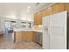 Kitchen featuring stainless dishwasher, wood cabinets, white refrigerator and breakfast bar with a backyard view at 16100 W Galleria Ln, Surprise, AZ 85374